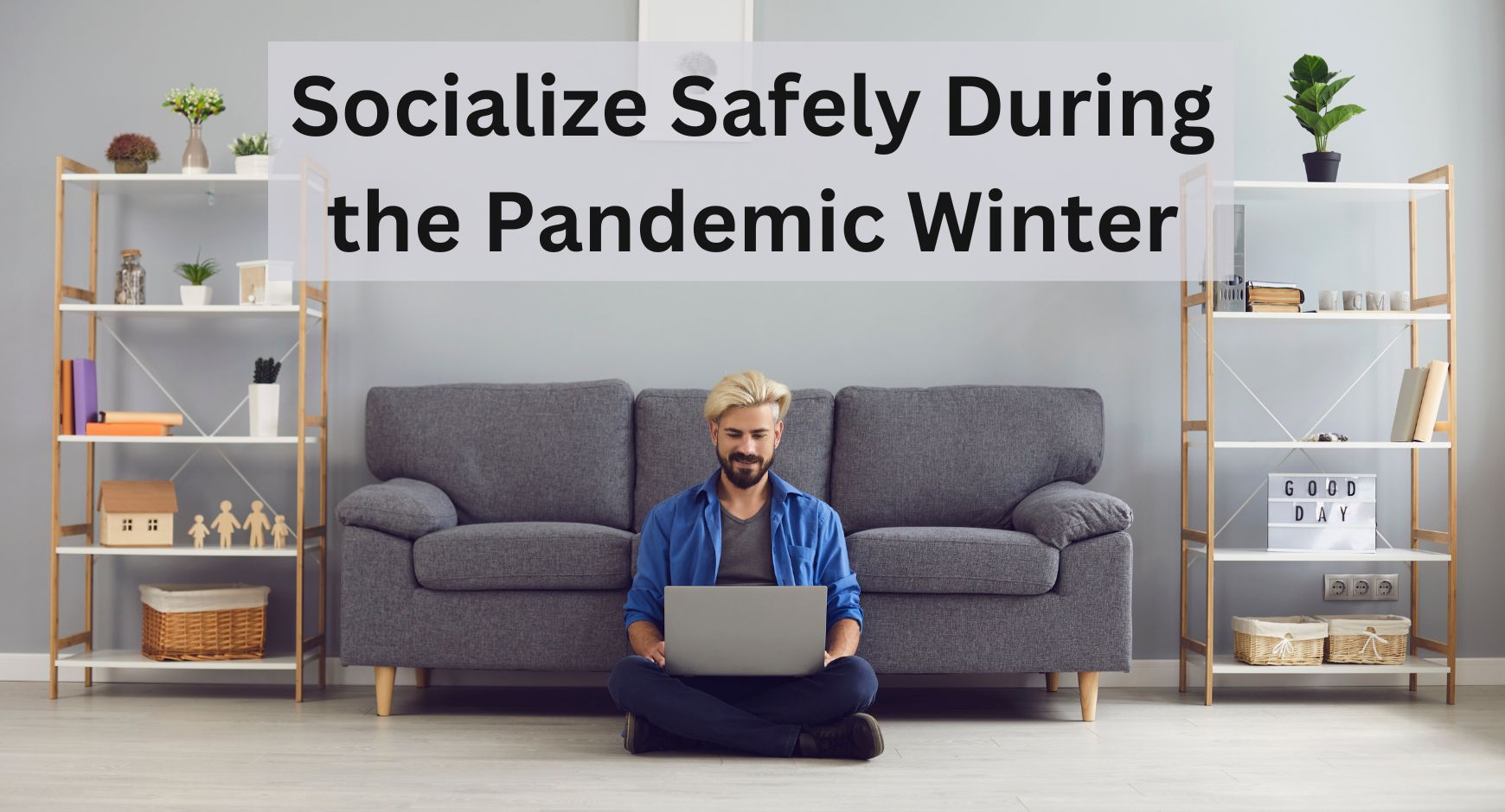 A man sitting along in his living room on a laptop under words that read "Socialize Safely During the Pandemic Winter"