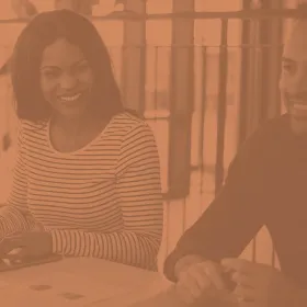 image of two people sitting side by side and smiling